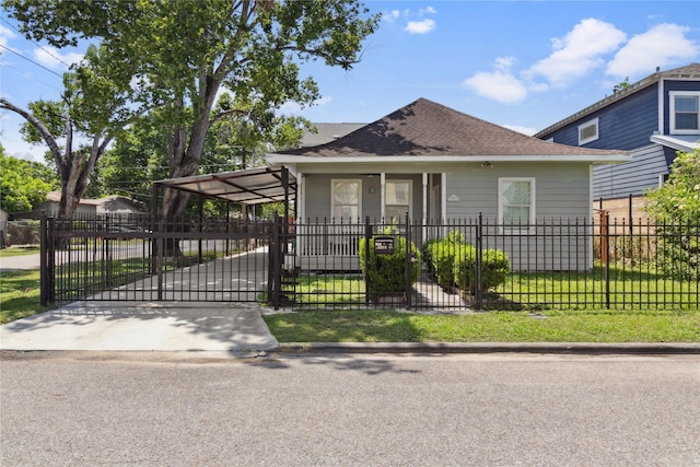 bungalow-style home with a fenced front yard, a shingled roof, a gate, and a carport