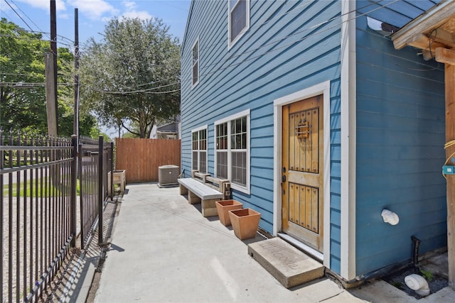 view of property exterior featuring fence, a patio area, and central AC unit