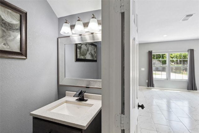 bathroom featuring marble finish floors and vanity