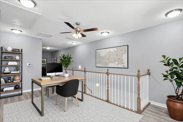 office space with attic access, wood finished floors, ceiling fan, and baseboards