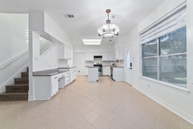 20415 Longspring Dr, Katy, TX 77450 - kitchen with stainless steel gas range, a chandelier, under cabinet range hood, and light tile patterned floors