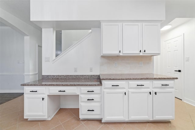 20415 Longspring Dr, Katy, TX 77450 - kitchen featuring light tile patterned flooring, dark stone countertops, white cabinets, and baseboards