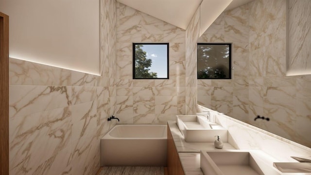 full bathroom featuring tile walls, a garden tub, double vanity, and vaulted ceiling