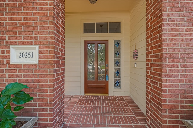 property entrance featuring french doors and brick siding