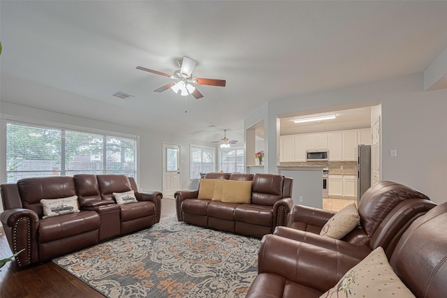 living area featuring a ceiling fan and wood finished floors