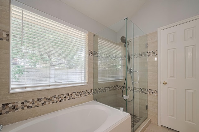 bathroom with a stall shower, healthy amount of natural light, and a bath