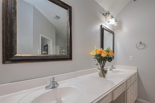 full bathroom featuring double vanity and lofted ceiling