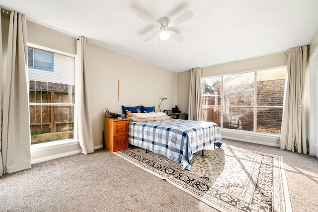 bedroom featuring carpet, multiple windows, baseboards, and lofted ceiling