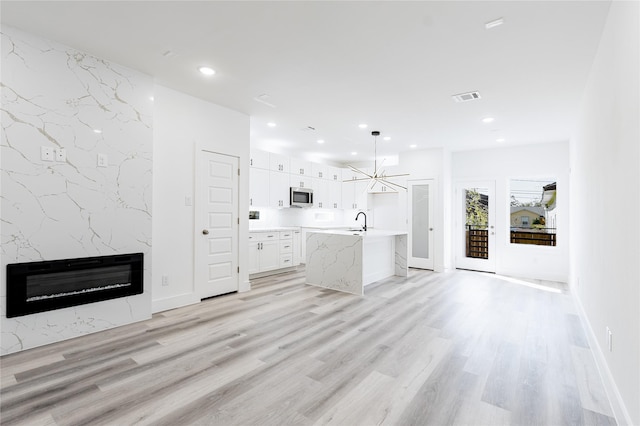610 E 41st St Unit A B, Houston, TX 77022 - unfurnished living room featuring a sink, a high end fireplace, light wood-style floors, recessed lighting, and heating unit