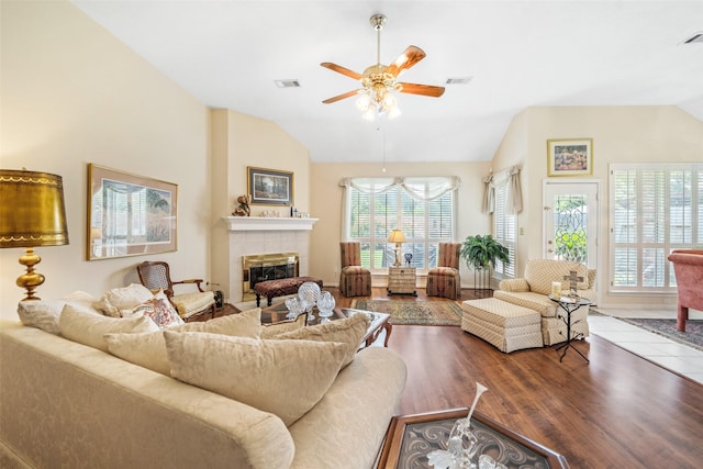 12938 Quail Park Dr, Cypress, TX 77429 - living area featuring vaulted ceiling, a tile fireplace, ceiling fan, and wood finished floors