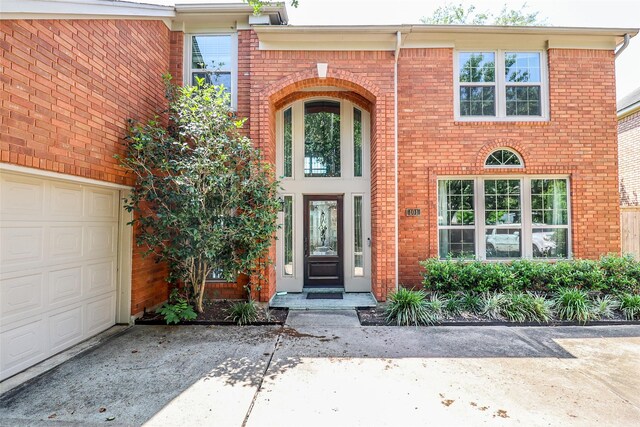 101 N Hall Dr, Sugar Land, TX 77478 - doorway to property with a garage, brick siding, and concrete driveway