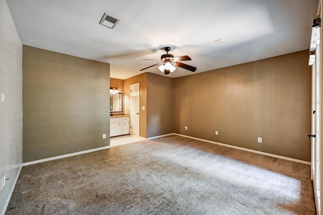 empty room with ceiling fan, light carpet, and baseboards
