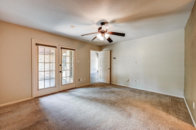 carpeted spare room featuring french doors, a ceiling fan, baseboards, and a textured ceiling
