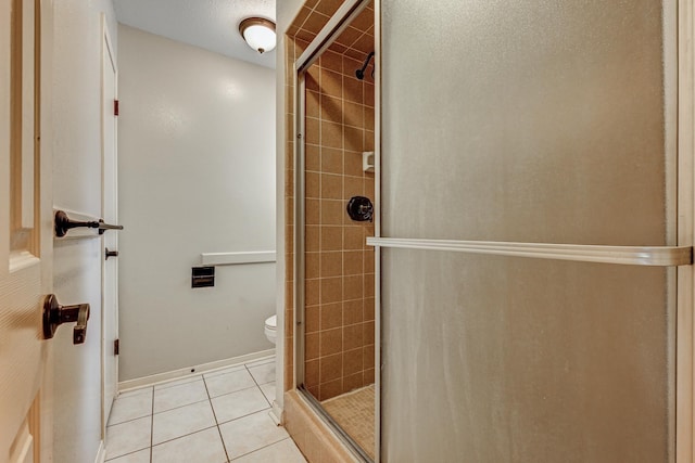 full bath with a stall shower, tile patterned floors, and toilet