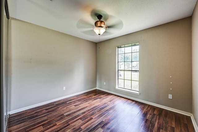 unfurnished room with dark wood-style flooring, baseboards, and ceiling fan