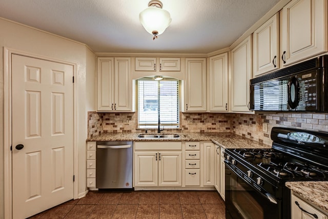 kitchen with black appliances, a sink, cream cabinetry, and a textured ceiling