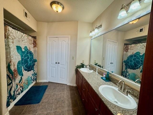 1711 Old Spanish Trl Unit 323, Houston, TX 77054 - full bathroom featuring tile patterned floors, double vanity, and baseboards