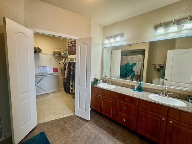 1711 Old Spanish Trl Unit 323, Houston, TX 77054 - bathroom with tile patterned floors, double vanity, and a walk in closet