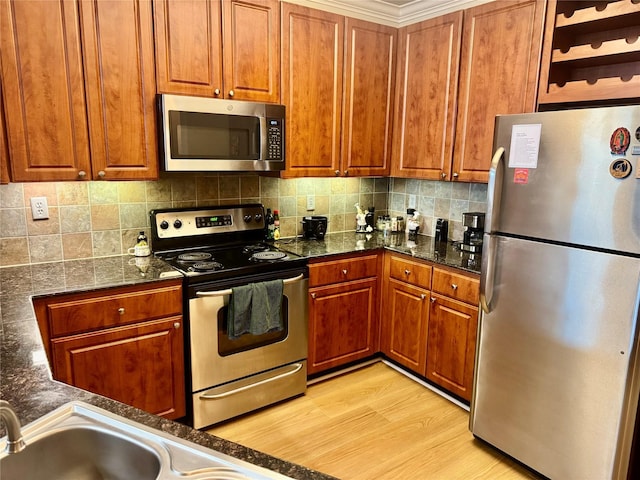 1711 Old Spanish Trl Unit 323, Houston, TX 77054 - kitchen with stainless steel appliances, tasteful backsplash, brown cabinetry, and dark stone countertops