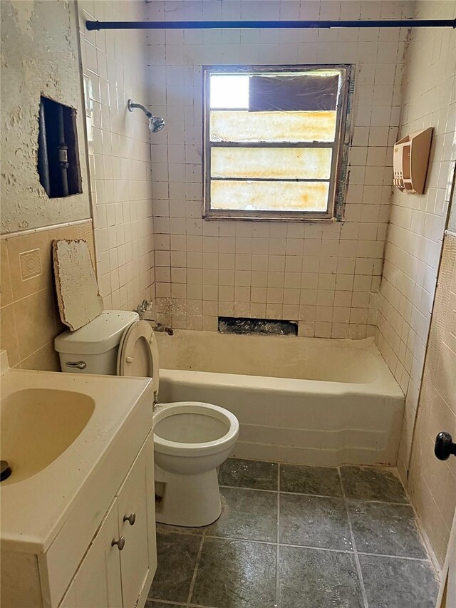 13339 Emporia St, Houston, TX 77015 - bathroom featuring toilet, stone tile flooring, tile walls, bathing tub / shower combination, and vanity
