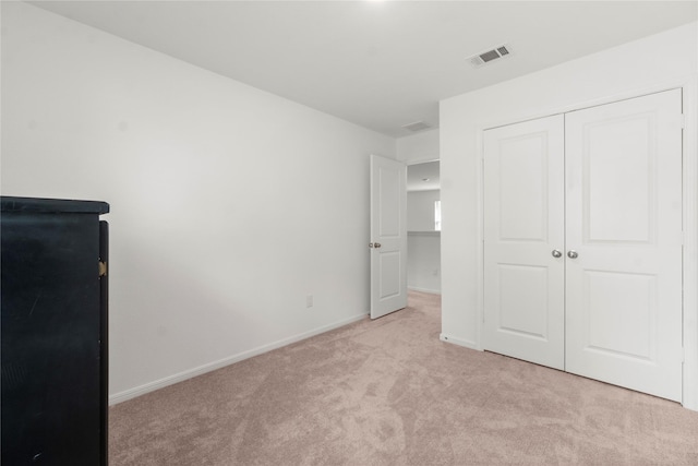 247 Pine Cavern Dr, Willis, TX 77378 - unfurnished bedroom featuring light colored carpet, a closet, and baseboards