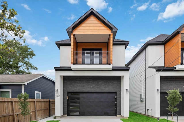 modern home featuring a balcony, a garage, fence, and stucco siding