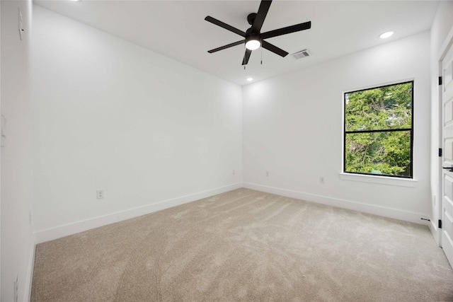 spare room featuring light colored carpet, a ceiling fan, baseboards, and recessed lighting