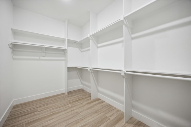 walk in closet with wood finished floors