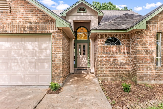 1408 Quail Holw, Sealy, TX 77474 - entrance to property with a shingled roof, brick siding, a garage, and concrete driveway