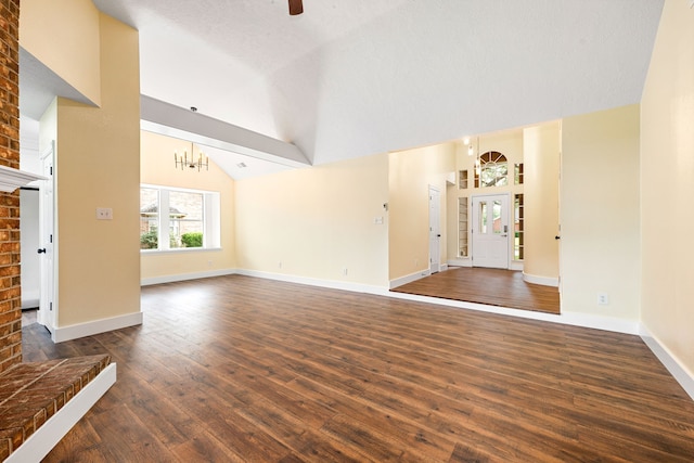 1408 Quail Holw, Sealy, TX 77474 - unfurnished living room featuring dark wood finished floors, a ceiling fan, baseboards, high vaulted ceiling, and a chandelier