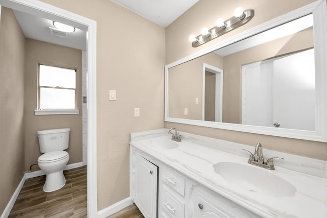 2257 County Road 206, Alvin, TX 77511 - bathroom with wood finished floors, toilet, baseboards, and double vanity