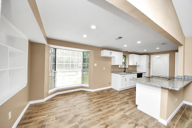 2257 County Road 206, Alvin, TX 77511 - kitchen with light wood-style floors, baseboards, white cabinets, electric stovetop, and light stone countertops