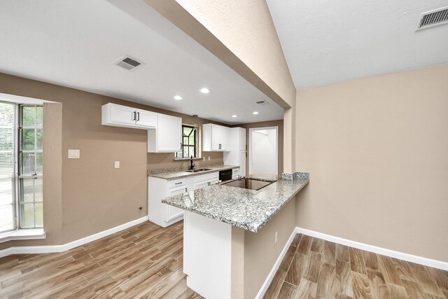2257 County Road 206, Alvin, TX 77511 - kitchen featuring light wood finished floors, baseboards, a sink, white cabinets, and light stone counters