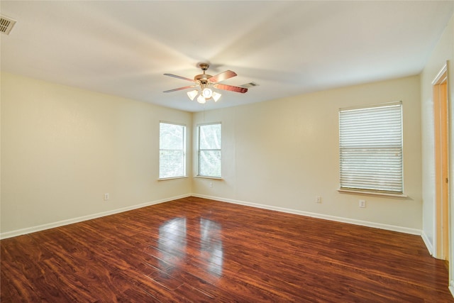 empty room with a ceiling fan, dark wood-type flooring, and baseboards