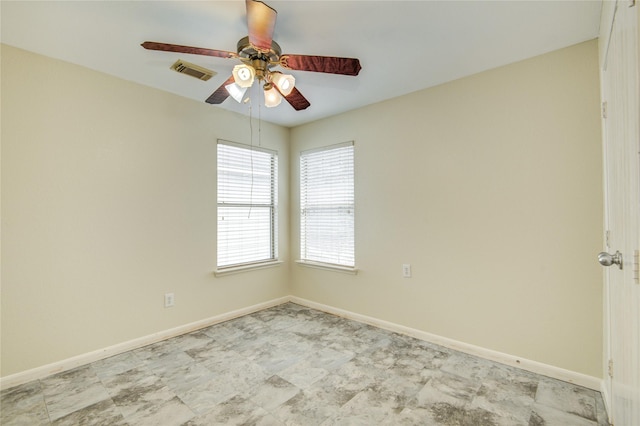 spare room featuring ceiling fan and baseboards