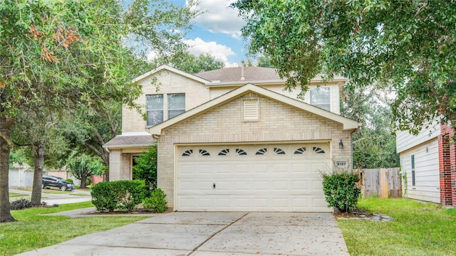traditional-style home featuring concrete driveway, a garage, and a shingled roof