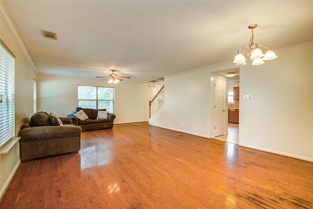 living room featuring crown molding, stairs, a ceiling fan, baseboards, and wood finished floors