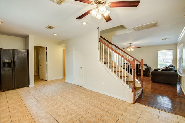 living room with ceiling fan, stairs, light tile patterned floors, and baseboards