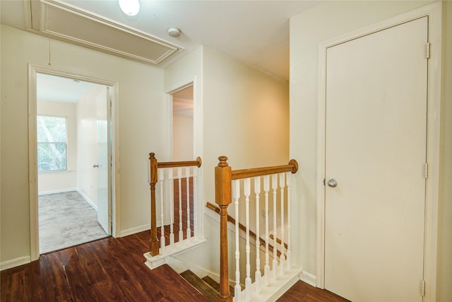 stairs with attic access, wood finished floors, and baseboards