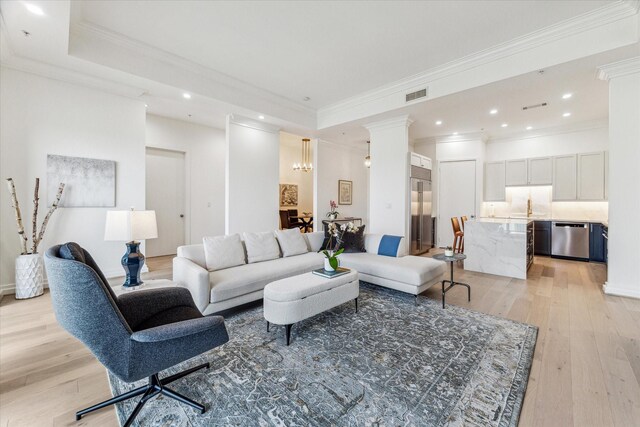 living area featuring light wood-type flooring, a chandelier, recessed lighting, and ornamental molding