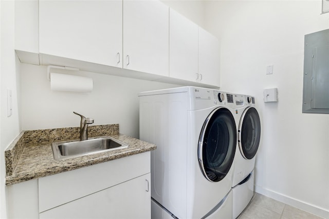 clothes washing area with washing machine and dryer, electric panel, cabinet space, and light tile patterned flooring