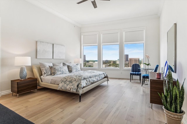 bedroom with ornamental molding, light wood-style flooring, baseboards, and a ceiling fan