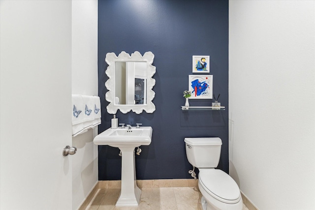 half bath with toilet and baseboards