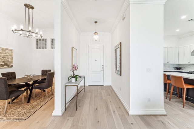 hallway with light wood-type flooring, a chandelier, ornamental molding, baseboards, and recessed lighting