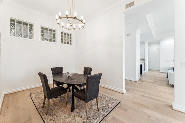 dining area with a chandelier, ornamental molding, light wood-type flooring, and baseboards