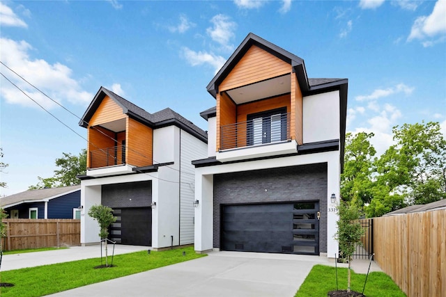 contemporary home featuring a balcony, an attached garage, fence, concrete driveway, and stucco siding