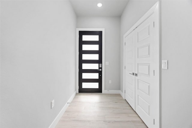 doorway with light wood-style flooring, baseboards, and recessed lighting