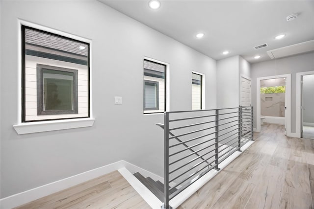 corridor featuring an upstairs landing, attic access, baseboards, wood finished floors, and recessed lighting