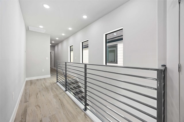 hall featuring baseboards, recessed lighting, an upstairs landing, and light wood finished floors