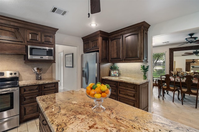 104 Smith Ln, League City, TX 77573 - kitchen with stainless steel appliances, ceiling fan, backsplash, dark brown cabinetry, and recessed lighting